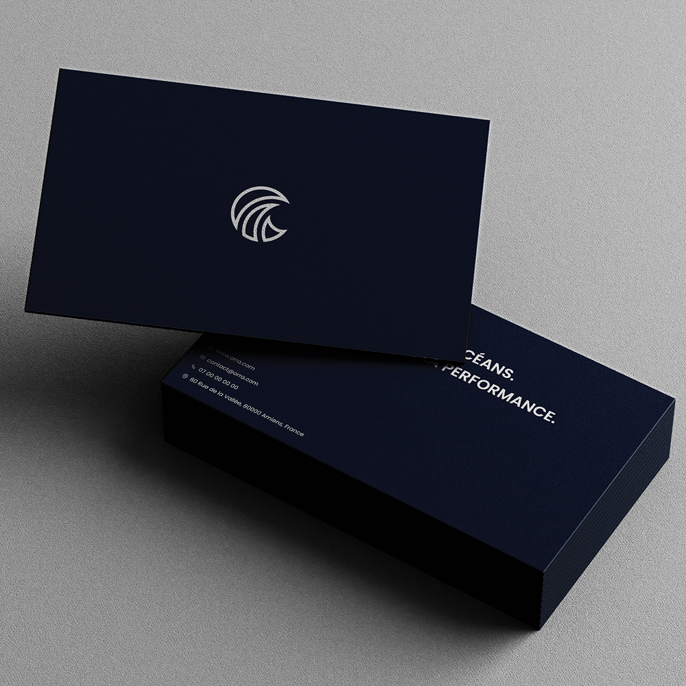 Carte de visite bleu foncé avec logo blanc minimaliste posée sur une pile de cartes